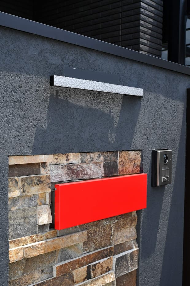 黒い門扉と赤いポストで高級感のあるモダン外構