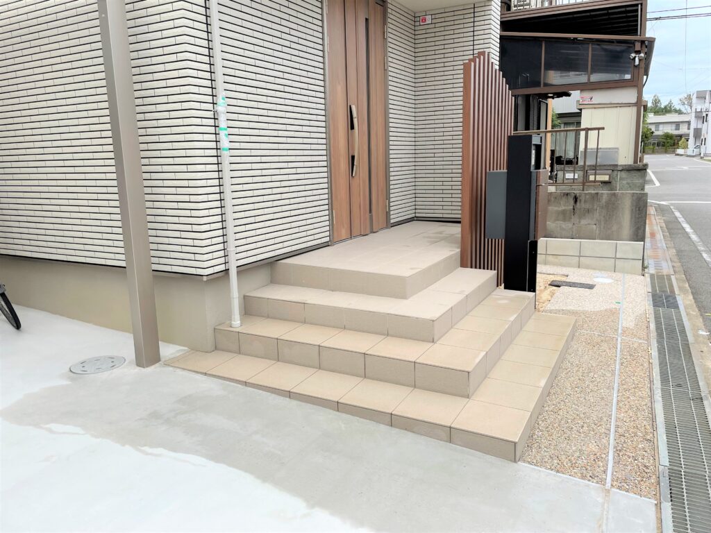 岡崎市で施工した洗い出し仕上げのアプローチと木目調の宅配ボックス付き機能門柱