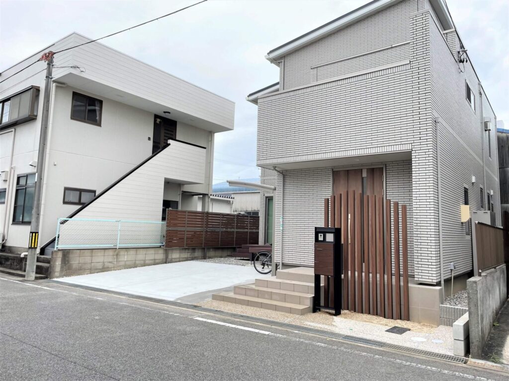 岡崎市の住宅玄関前に曲線状に配置したLIXIL枕木風角柱の目隠し兼転落防止柵